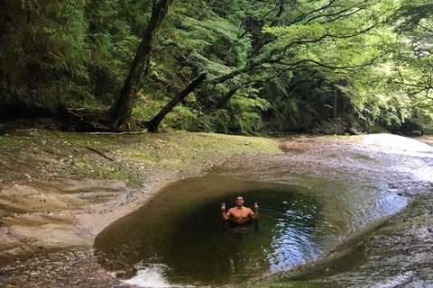 Picture of a water hole with a man posing in it